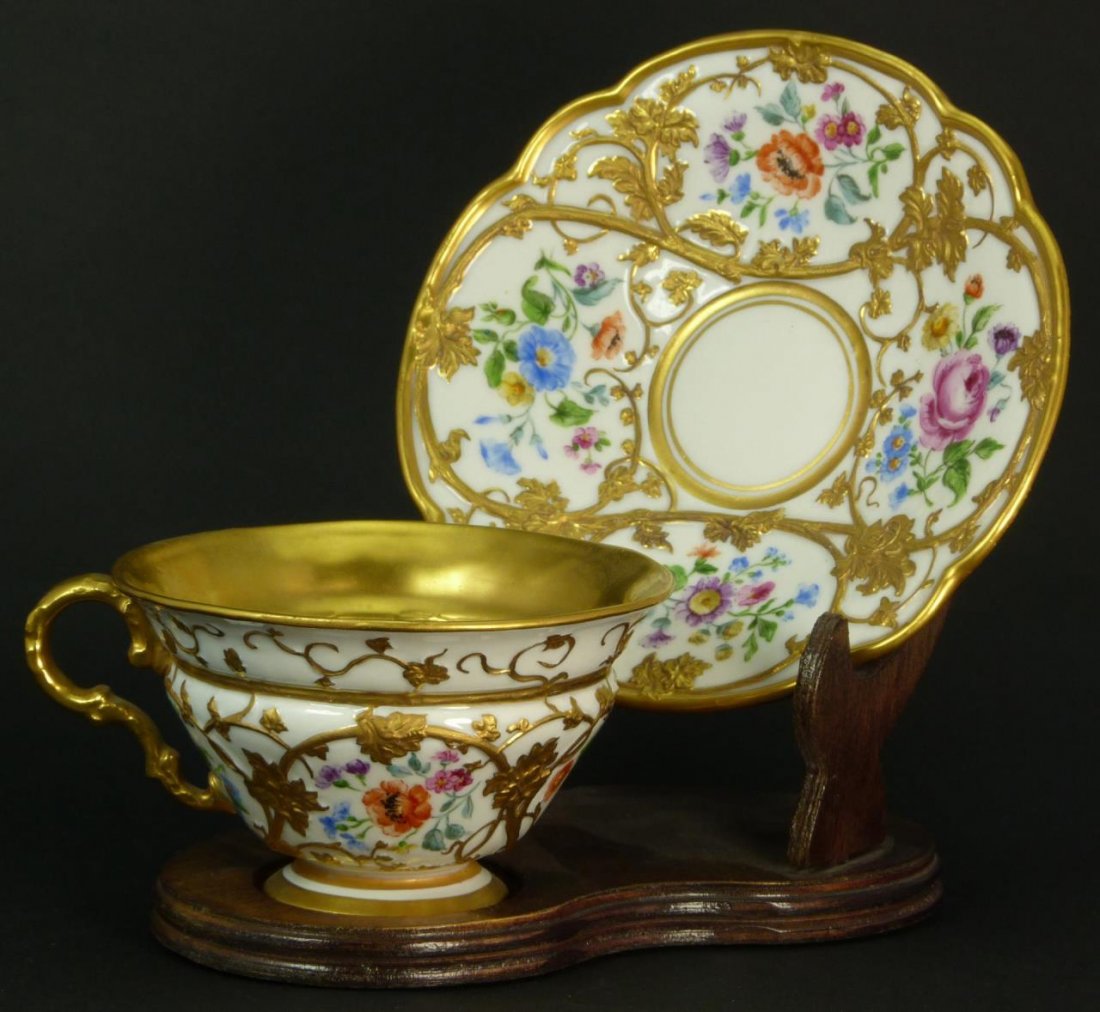 MEISSEN LARGE ANTIQUE CUP & SAUCER: Meissen hand painted floral design antique cup and saucer with raised antique gold trim. Bears the cross swords mark to base. Circa 1925. Measures approx 5 1/2" (13.97cm) Width. Total approx weight 29