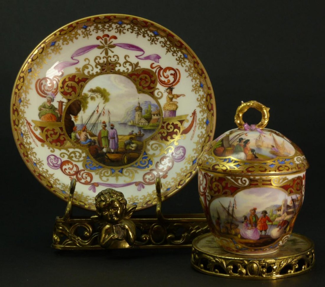 MEISSEN ANTIQUE COVERED CUP & SAUCERS 3PIECE SET: Meissen antique covered cup & saucers three piece set depicting a dock scene in old Italy. Bears the cross swords mark under glaze to base. Saucers measures 4 1/4" (10.79cm) Diameter. Total approx wei