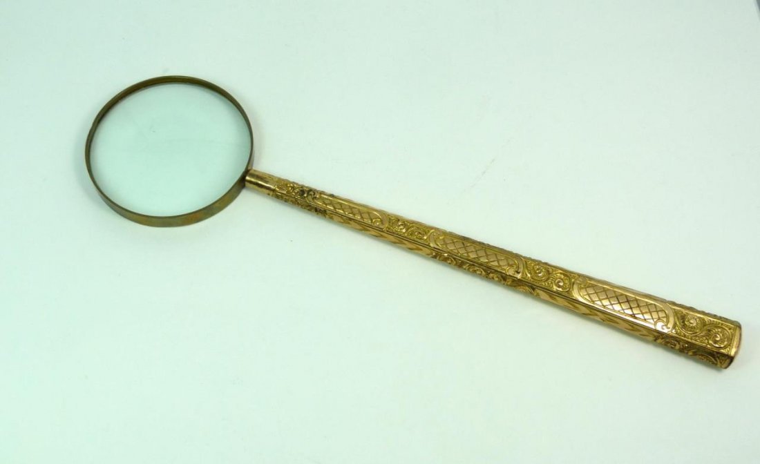 14KT OVERLAY MAGNIFYING GLASS: 14kt overlay magnifying glass with a beautifully scrolled gold leaf handle. Circa early 20th century. Measures approx 15 1/2" (39.37cm) Length. Total weight 360g.