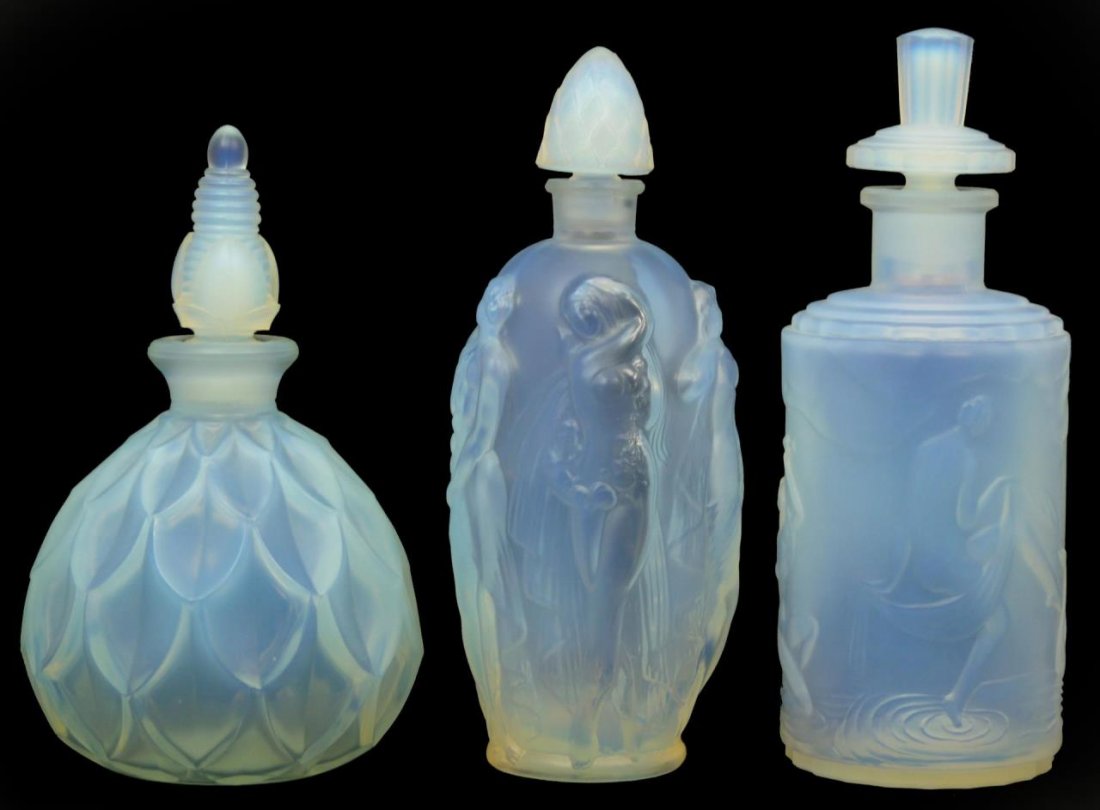 LOT OF THREE SABINO FRENCH PERFUME BOTTLES: Lot of three Sabino French glass perfume bottles. Consisting of a bottle surrounded by five nude women, a Frivolites bottle and a feathered designed bottle. All signed "Sabino Paris" to base. Largest 
