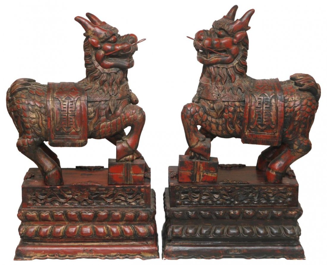 PAIR OF CHINESE PALATIAL CARVED WOODEN FOO DOGS: Red toned. Pair adorned a Palm Beach mansion for many decades. Each measure approx 22" (55.88cm) Wide x 27" (68.58cm) Tall and sits atop of a 12" (30.48cm) Tall matching base. Each weighs approx 30lbs