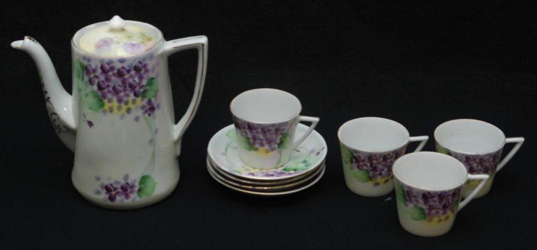 ANTIQUE NIPPON HAND PAINTED CHOCOLATE SET: With a violet motif, consisting of a chocolate pot and four cups and saucers. Dates to the early 20th century. Pot measures 7" (17.78cm) Tall. Total collective weight 1.64kg.