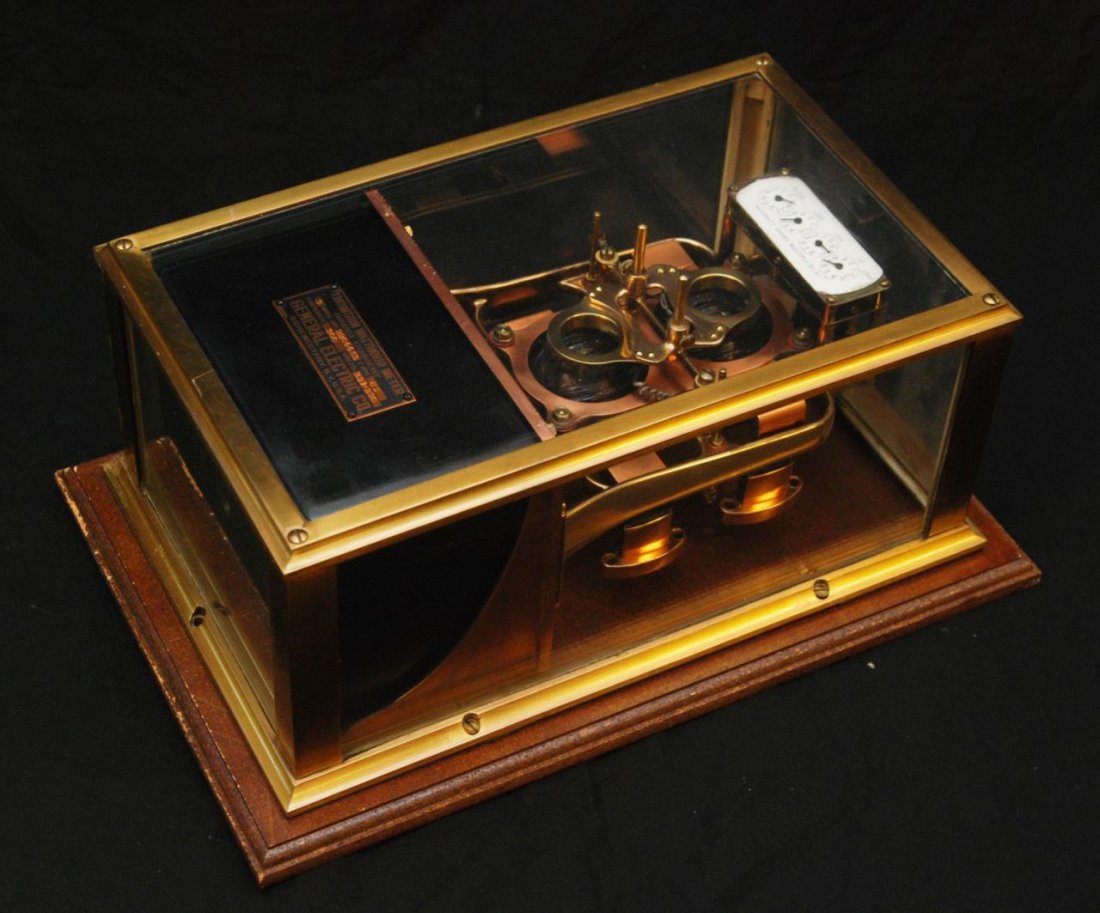 VTG THOMSON WATTHOUR METER FOR GENERAL ELECTRIC: Early to mid 20th century General Electric meter. Made of all copper and brass. Incased in a heavy brass and glass case, which is mounted on a heavy board for wall mounting. Attached black reads Thoms