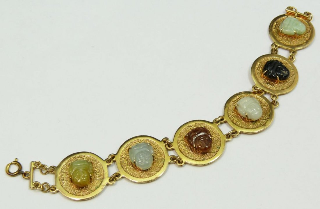 CHINESE 14K YG MULTI COLOR JADEITE HOTEI BRACELET: Vintage Chinese 14K yellow gold coin link bracelet set with a Hotei Buddha jadeite carving to each link. White, green, russet and black color stones can be seen. The black is probably not jade but all