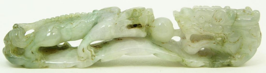 ANTIQUE LAVENDER & GREEN JADEITE GARMENT HOOK: Antique Chinese lavender and green jadeite garment hook having a ruyi scepter form and depicting Chih Lung dragons with pearl. Circa Qing dynasty period, 19th century. Measures approx 6" (15.24cm) Len