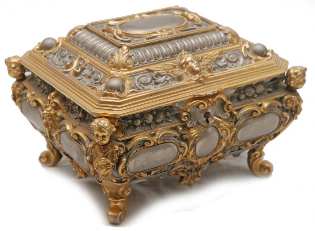 ITALIAN GILT METAL LOCKING CASKET JEWELRY BOX: Vintage Italian gilt metal jewelry box with locking mechanism to front. Includes insert. Beautiful design with cherubs and fruit. Impressed marks to bottom. Measures approx. 5 3/4" height x 8 1/4" wid