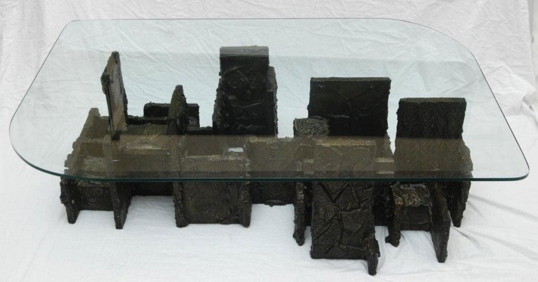 PAUL EVANS BRUTALIST BRONZED WOODEN COFFEE TABLE: Paul Evans geometric brutalist coffee table with beveled glass top. Signed to side of base and dated '74. Base measures approx. 15 1/4" height x 48" length x 31" depth (38.7cm x 122cm x 78.8cm). Glass