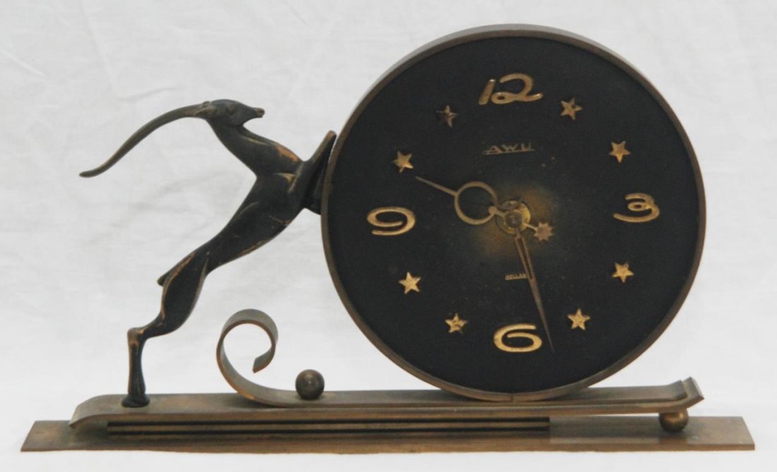 VINTAGE DECO STYLE AWU HOLLAND IMPALA CLOCK: A vintage 1950's clock having an Art Deco design with an impala. Arabic numerals over blackened metal face with star applique notches. Old 'Fa Jan M. Pierrot' label to verso. Measures approx. 7" heigh