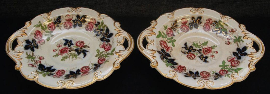 Pr. ANTIQUE ENGLISH PORCELAIN FOOTED HANDLED TRAYS: A pair of antique porcelain footed dishes with handled design. Scalloped rim with scrolled gilt accenting throughout. Bottoms hold impressed star and cross in clover mark. Red enameled over glaze inve