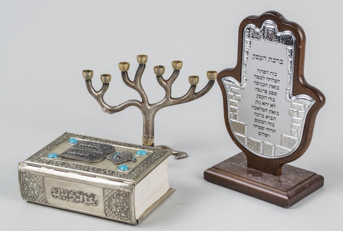 Group of Judaica Articles: Menorah, book and plaque. Menorah height 4 1/2 inches. Notice to bidders: Condition reports and additional photographs are provided by request as a courtesy to our clients, as such any condition repor