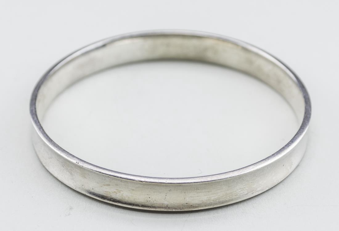 Hans Hansen Sterling Silver Bangle: Scandinavian, concave design. Inside diameter 2 1/2 inches, 32 grams. Notice to bidders: Condition reports and additional photographs are provided by request as a courtesy to our clients, as such any