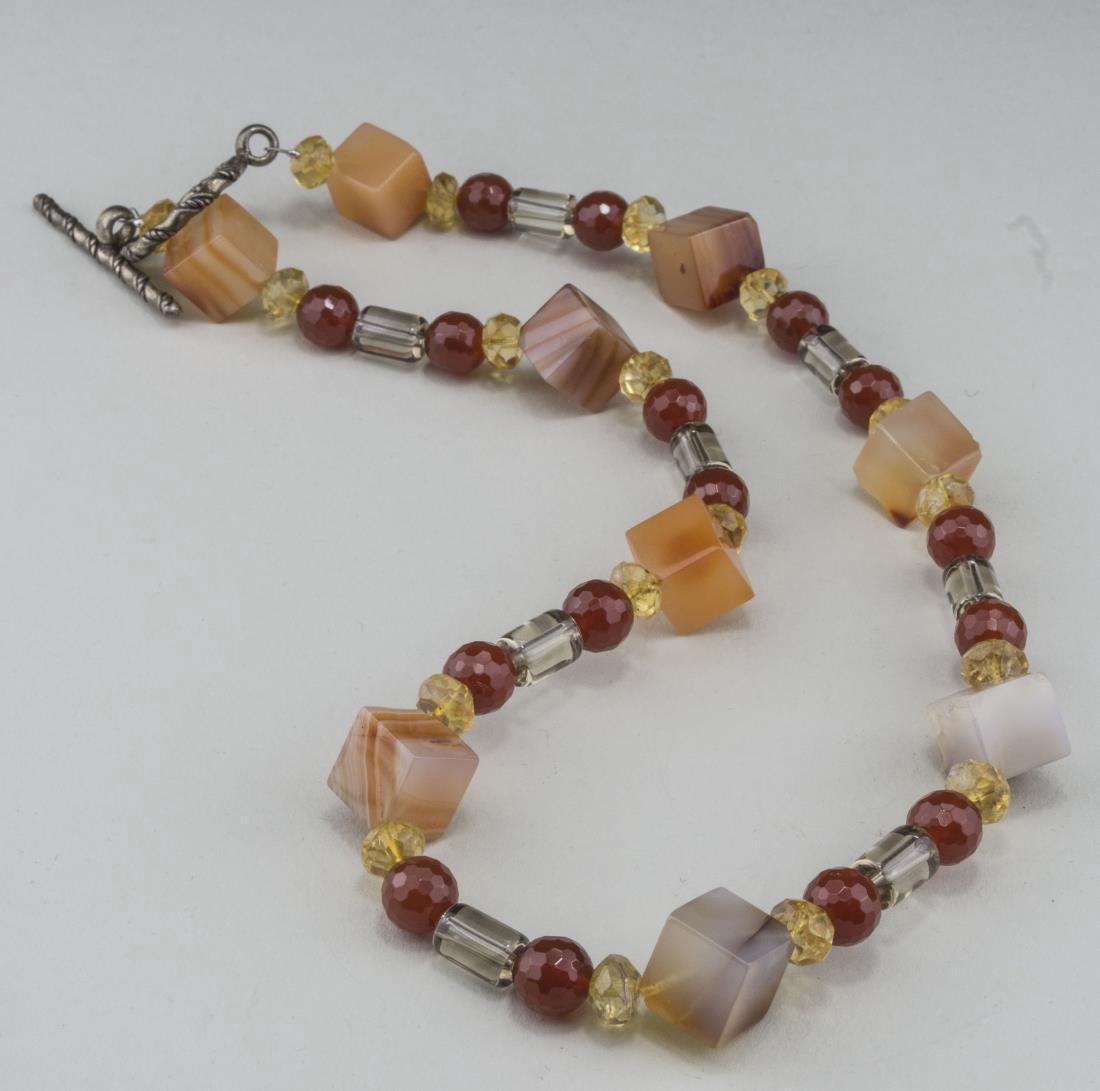 Carnelian and Rock Crystal Bead Necklace: Carnelian cube beads accented with, citrine, agate and smoky topaz beads, sterling silver clasp. Length 18 inches. Notice to bidders: Condition reports and additional photographs are provided by reque