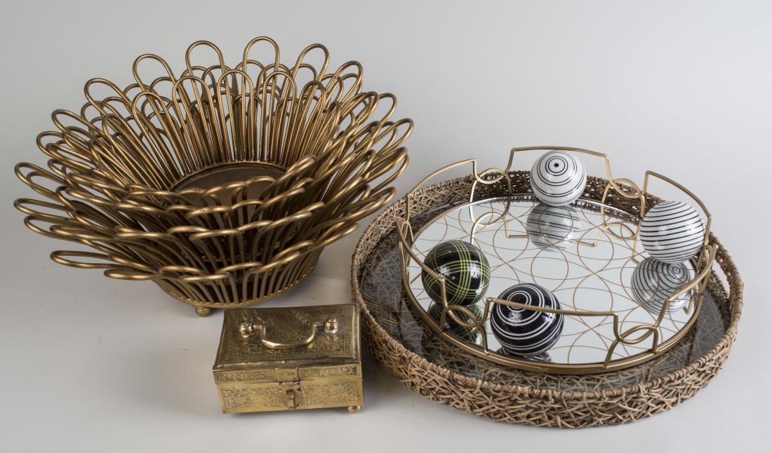 Group of Table Decorations: Comprising of two pairs of gold painted baskets, two round trays, four decorative orb, and a brass box. Larger tray diameter 19 inches. Notice to bidders: Condition reports and additional photographs 