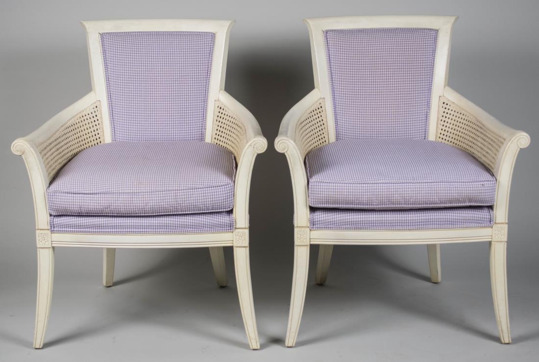 Pair of Ethan Allen White Painted Armchairs: Trapezoid upholstered back on outscrolled arms with caned side panels, cushion seats, slightly splayed legs. Height 37 inches, width 29 inches, depth 28 inches. Notice to bidders: Condition reports an