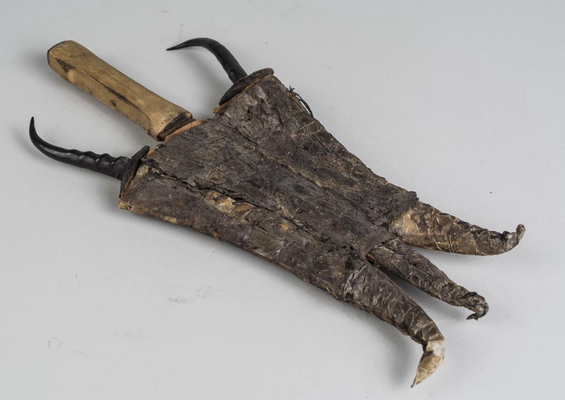 Set of Three African Daggers: One a double edged blade with bone handle, and two single edged curved blades with horn handles, each with a calligraphy decorated blade and all in a single crocodile skin sheath. Double edged blade l
