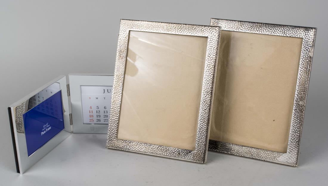 Three Silvered Metal Picture Frames: Two with hammered finish, inside 9 x 7 inches, together with and double picture frame. Notice to bidders: Condition reports and additional photographs are provided by request as a courtesy to our clie