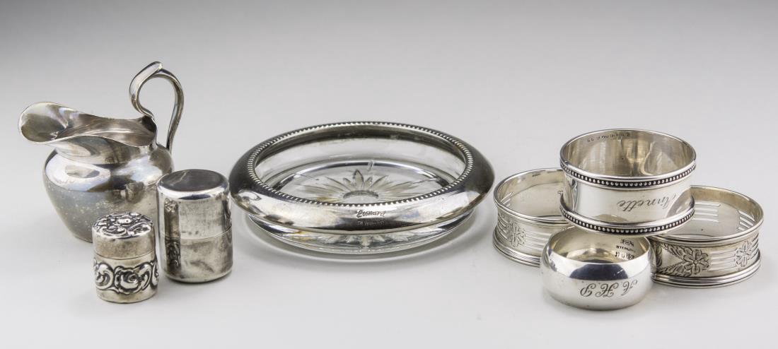Group of Silver Table Articles: Four sterling silver napkin rings, two sterling silver thread holders, silver plated measuring jug and an Italian coaster. Total approximately 96 grams, weighable. Coaster, diameter 4 inches. Notice t