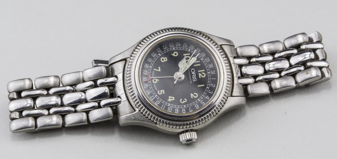 Oris 754 Wristwatch: Black dial with Arabic numerals and days of the month calendar, sapphire crystal, 17 jewels, skeletonized back, stainless steel band, Notice to bidders: Condition reports and additional photographs ar
