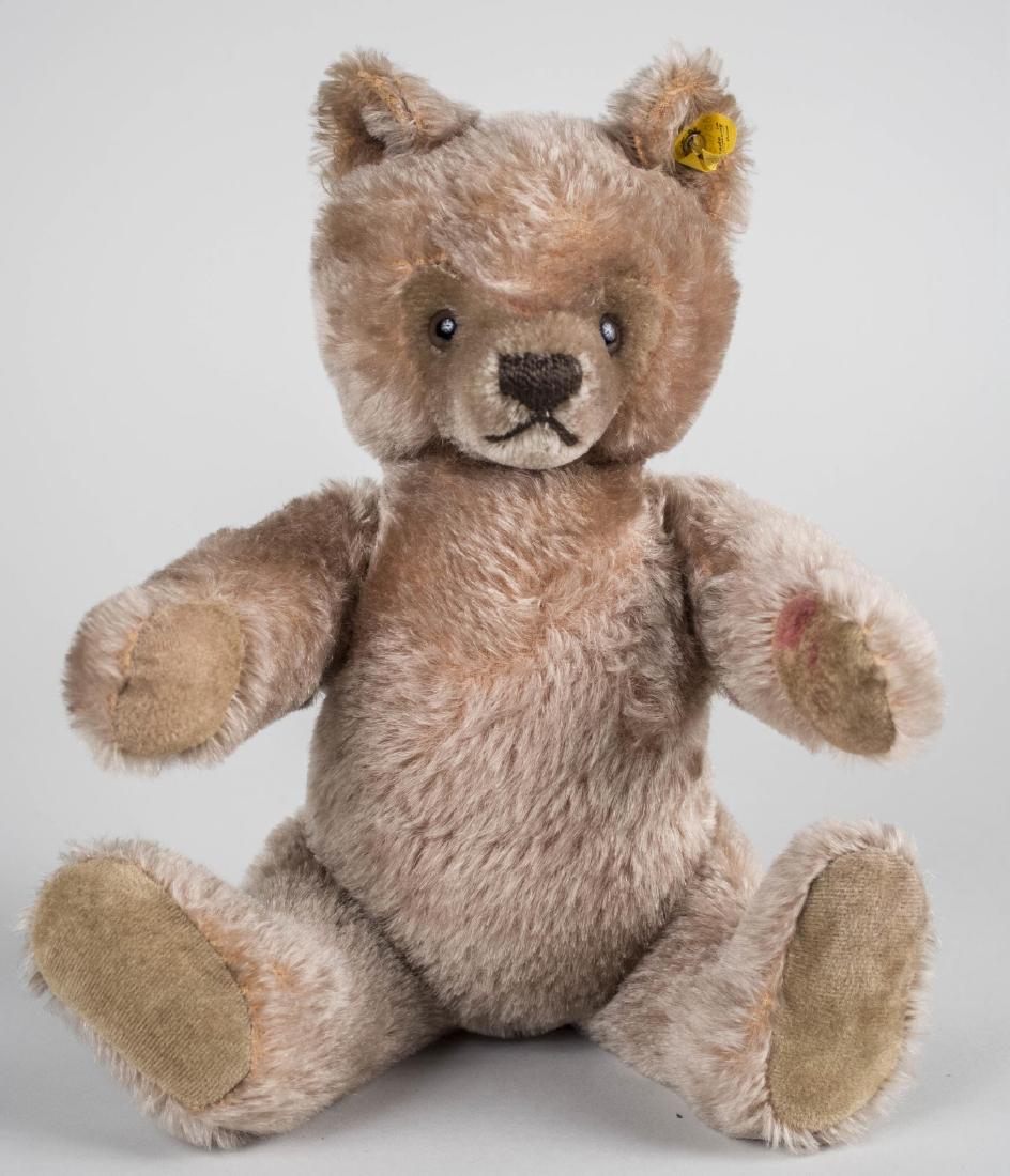 Steiff Teddy Bear: Glass eyes, stitched nose, moveable arms and legs, Steiff label in his ear. Height 13 inches. Notice to bidders: Condition reports and additional photographs are provided by request as a courtesy to o