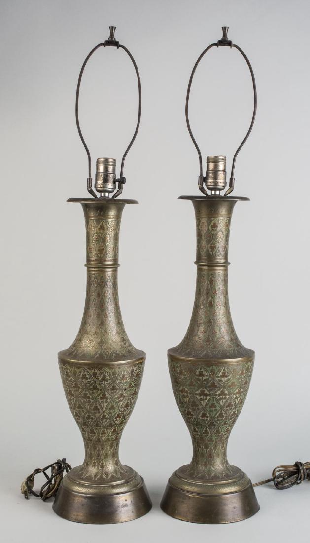 Pair of Brass Lamps: Vase form single light lamps with arabesque decoration. Base, height 20 1/2 inches. Notice to bidders: Condition reports and additional photographs are provided by request as a courtesy to our clients