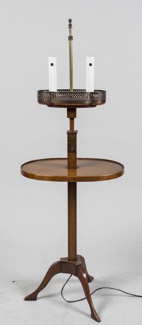 Mahogany Lamp Table: Two light lamp table with central oval shelf. Height 50 inches. Notice to bidders: Condition reports and additional photographs are provided by request as a courtesy to our clients, as such any condit