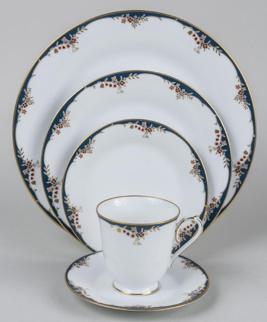 Noritake Porcelain Dinner Service: comprising twelve dinner plates, twelve salad plates, twelve bread plates, twelve soup bowls, twelve fruit bowls, twelve cups and saucers, cream and sugar, vegetable bowl, platter. Dinner plate, diame