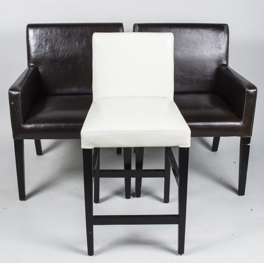 Three Crate & Barrel Leather Chairs: Two black leather armchairs and a white leather stool. Stool, height 38 inches, width 19 inches, depth 18 inches. Notice to bidders: Condition reports and additional photographs are provided by reques