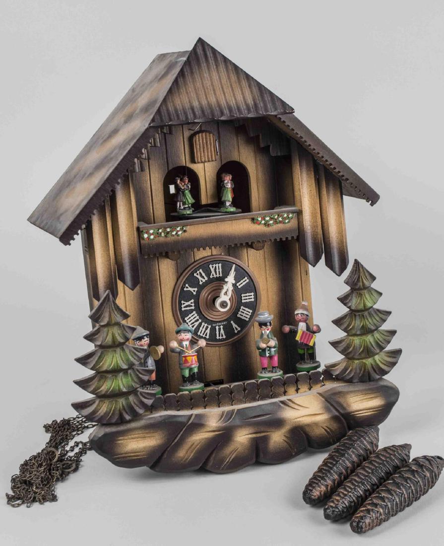 German Cuckoo Clock: Polychrome painted, with black painted face with roman numeral chapters, and animatronic dancers and musicians. Height 14 inches. Notice to bidders: Condition reports and additional photographs are pr