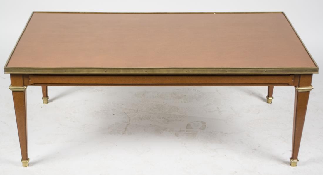 Maison Jansen Style Coffee Table: Rectangular top with brass edge on tapered square legs. Height 16 inches, width 42 inches, depth 24 inches. Provenance: From the Collection of Debra Newhouse Notice to bidders: Condition reports and a