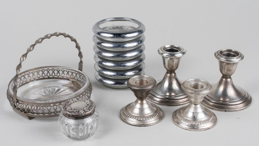 Group of Sterling Silver Articles: Comprising two pairs of weighted candlesticks, glass dresser bottle with sterling cover, set of silver plated coasters and basket. Larger candlestick, height 3 1/4 inches. Notice to bidders: Condition