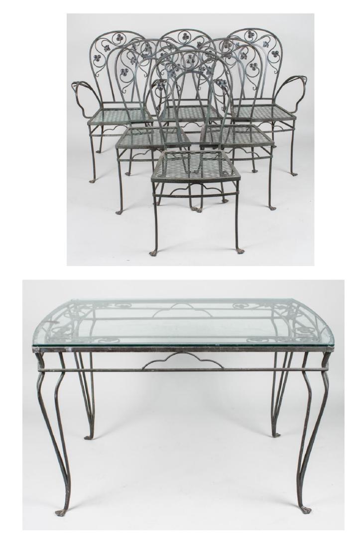 Cast Iron Patio Set: Comprising a glass top table, and six chairs all with fruiting vine decoration. Chair height 36 inches, width 25 inches, depth 21 inches. Notice to bidders: Condition reports and additional photograph