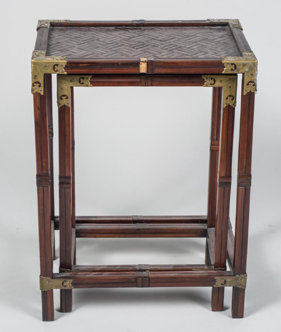 Asian Style Nest of Tables: Rectangular tops with brass corners, block legs joined by box stretcher. Height 22 inches, width 16 inches, depth 11 inches. Notice to bidders: Condition reports and additional photographs are provide