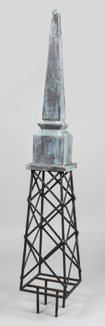 Garden Obelisk: Patinated metal tip, with an openwork frame body, on a square cement base (not shown). Height 77 inches. Notice to bidders: Condition reports and additional photographs are provided by request as a co