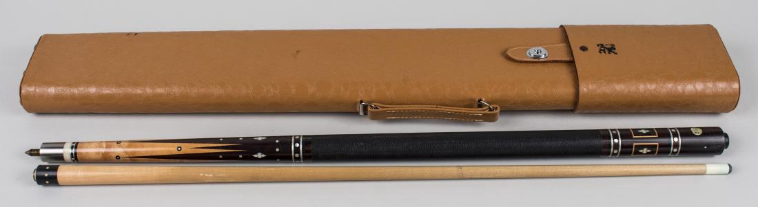 Adams Pool Cue: Two piece cue, with a black leather grip and hard case. Notice to bidders: Condition reports and additional photographs are provided by request as a courtesy to our clients, as such any condition repo