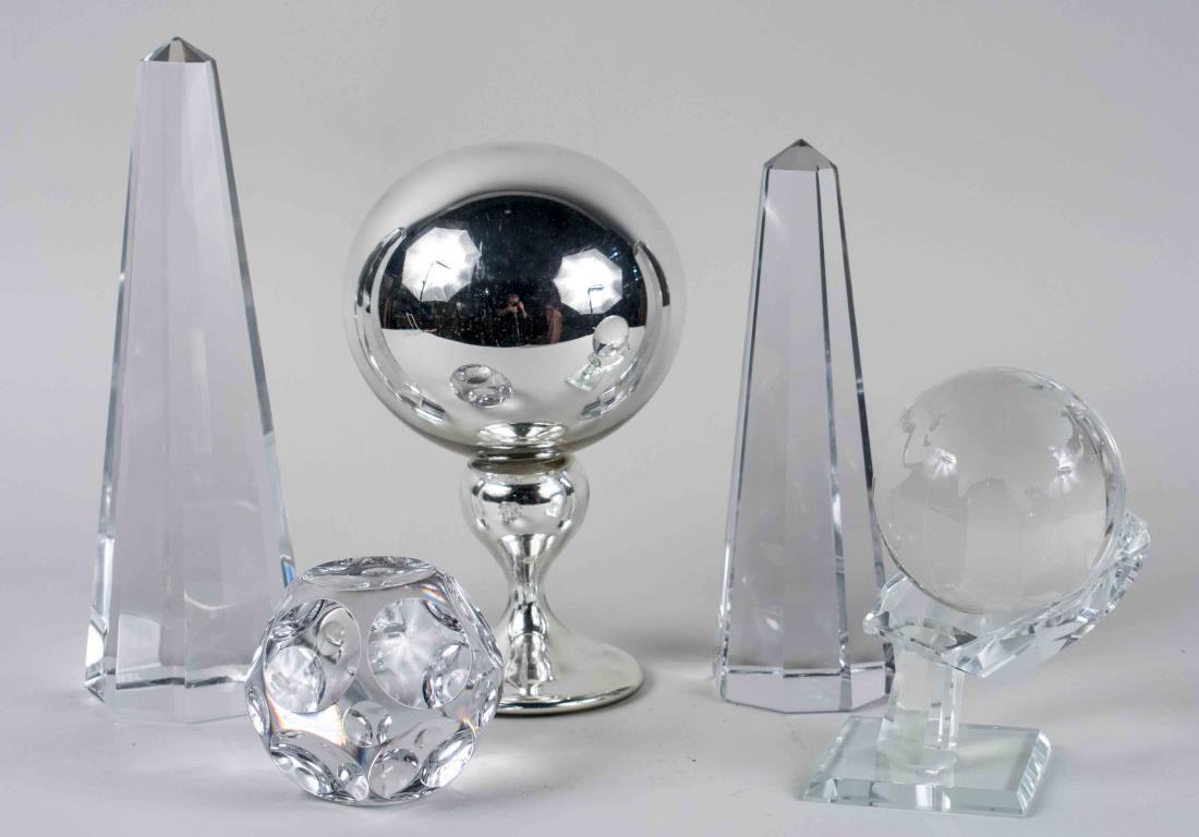 Five Glass Table Decorations: Two glass obelisks, a mercury glass centerpiece, a world globe on stand and a paperweight. Tallest, height 12 inches. Notice to bidders: Condition reports and additional photographs are provided by re