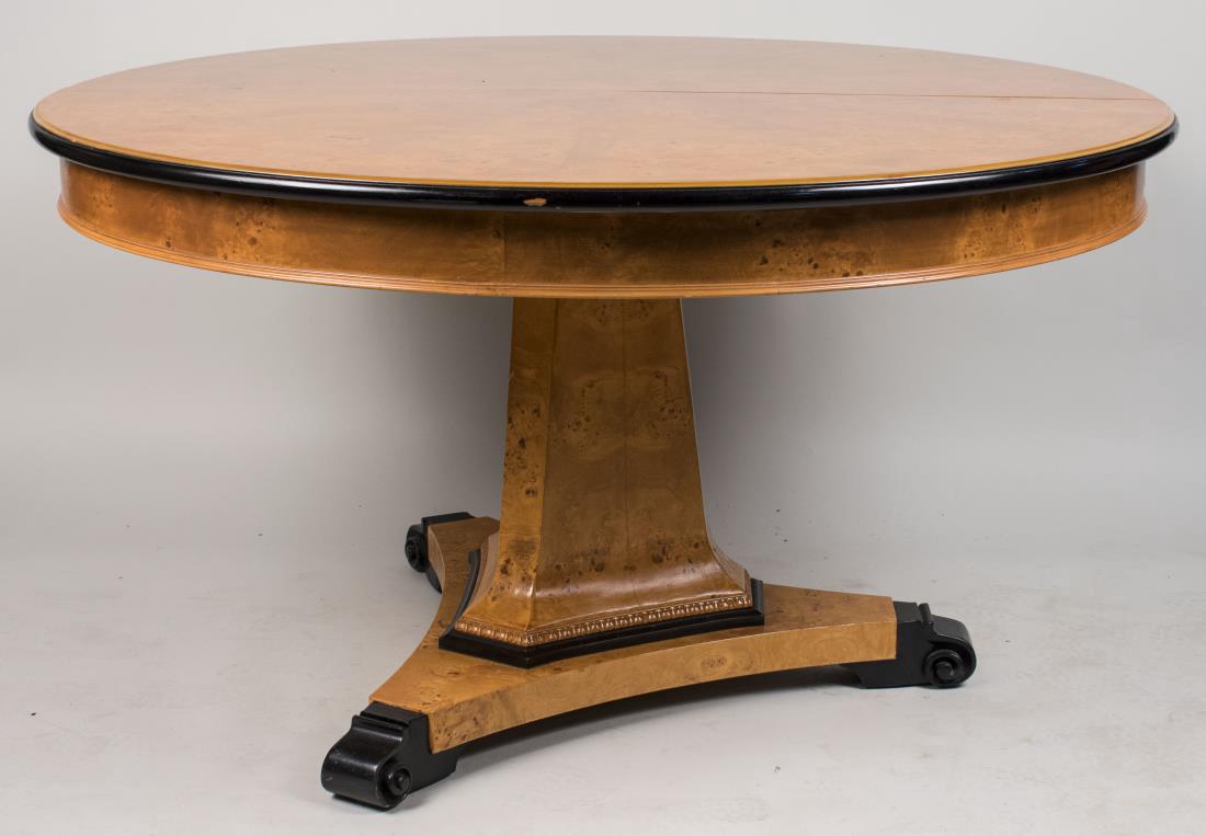 Biedermeier Circular Dining Table: Circular top with ebonized edge, on a tapered shaped triangular center support on a tripartite base with ebonized scroll feet, three additional leaves. Height 30 inches, diameter 54 inches. Leaf width