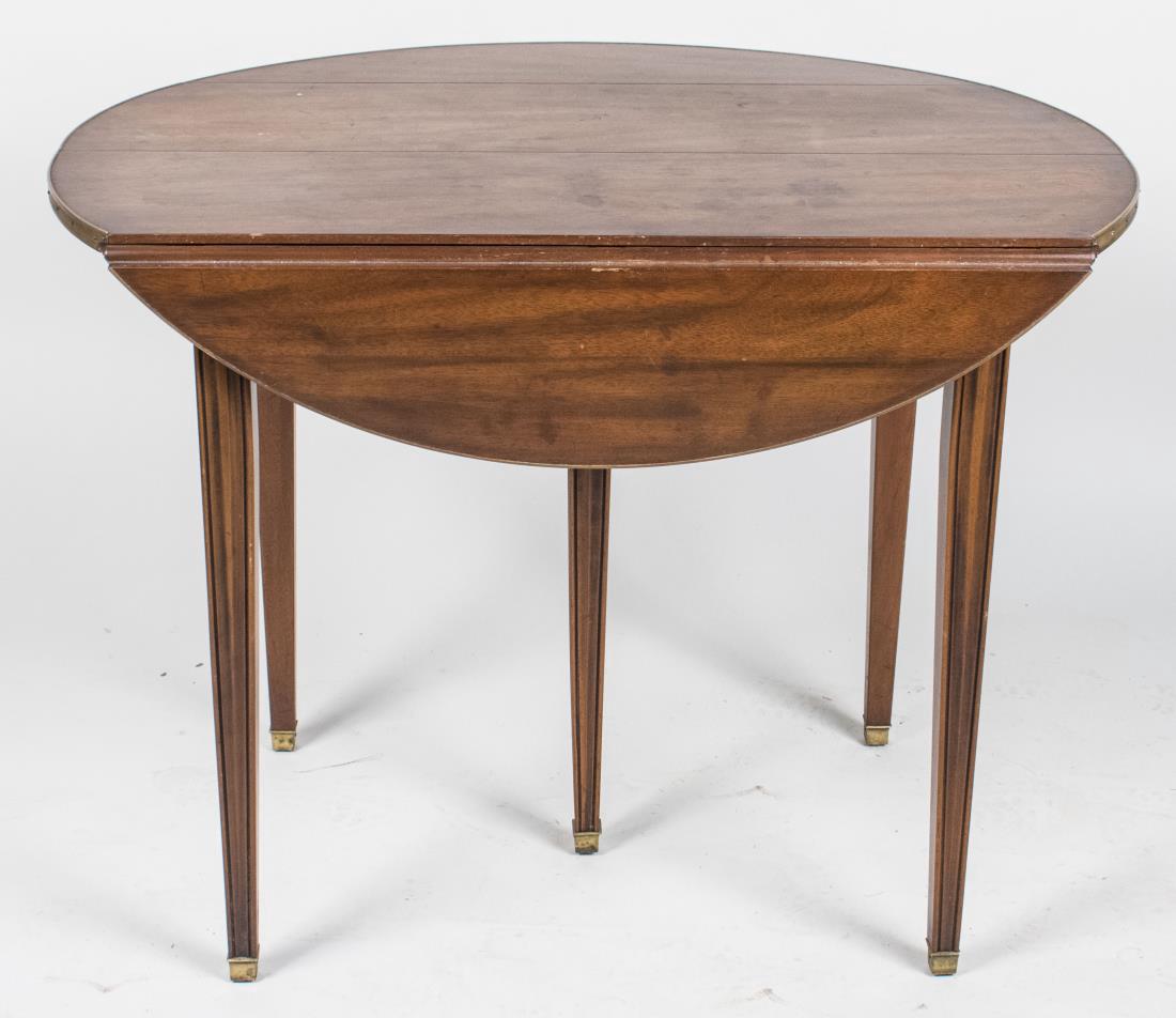 Extension Drop Leaf Dining Room Table: Oval drop leaf table with four additional leaves, all with brass banded edge. Open, not extended, height 29 inches, width 33 1/2 inches, length 38 inches, leaf width 13 1/2 inches. Notice to bidders: