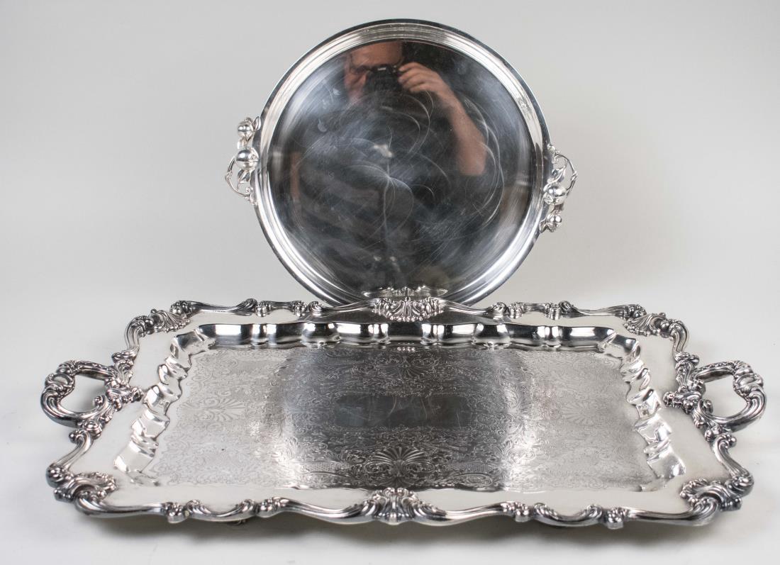 Two Silver Plated Serving Trays: One, Rococo style rectangular tray with scroll handles, the other a circular tray in the style of Georg Jensen, Rectangular tray, length over handles, 27 inches. Notice to bidders: Condition reports a