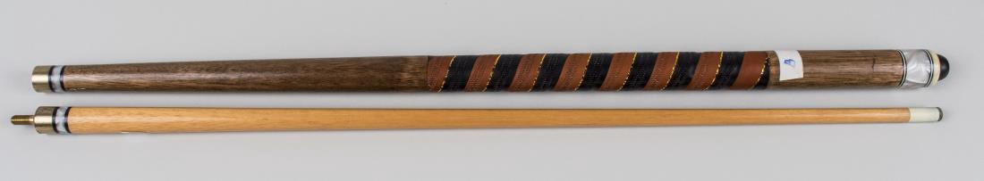Pool Cue: Two piece cue with a leather wrapped grip. Notice to bidders: Condition reports and additional photographs are provided by request as a courtesy to our clients, as such any condition report is only an