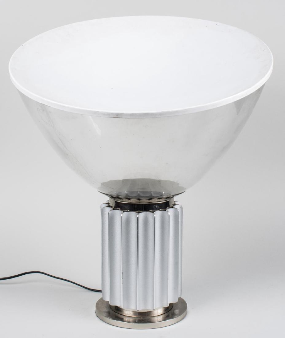 Achille and Pier Castiglioni Taccia Lamp: By Flos, with a clear inverted dome shade with a white convex reflector, on a fluted brushed metal up light. Height 24 inches. Notice to bidders: Condition reports and additional photographs are provi