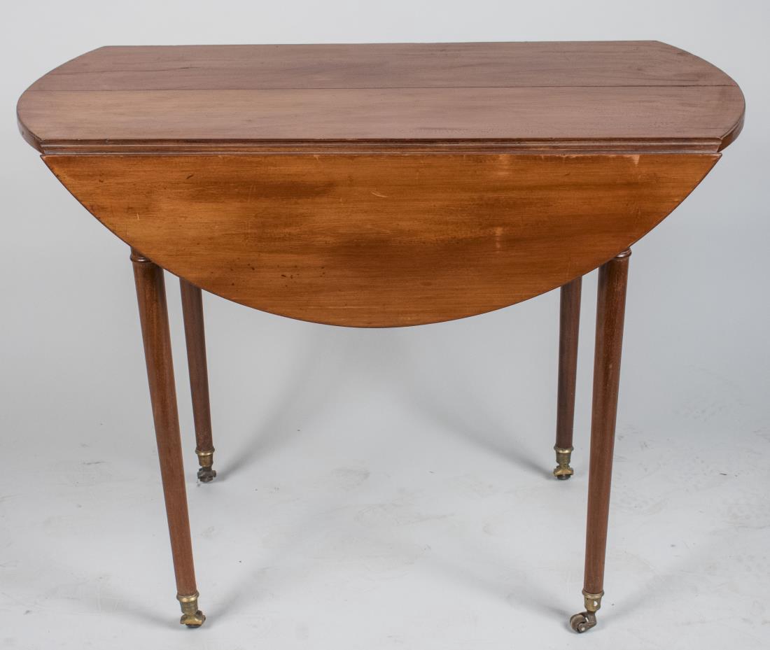 Drop Leaf Table: Shaped rectangular top with two drop leaves, on turned legs ending in brass casters. Closed, height 28 inches, width 37 1/2 inches, depth 21 inches. Notice to bidders: Condition reports and additional