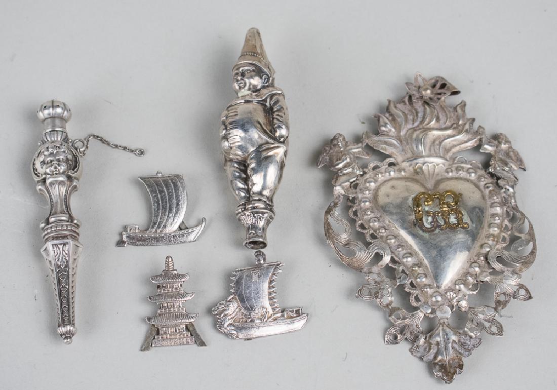 Silver Novelties: Including an armorial, a needle case, a whistle and three card holders. Total 34 grams. Notice to bidders: Condition reports and additional photographs are provided by request as a courtesy to our cli