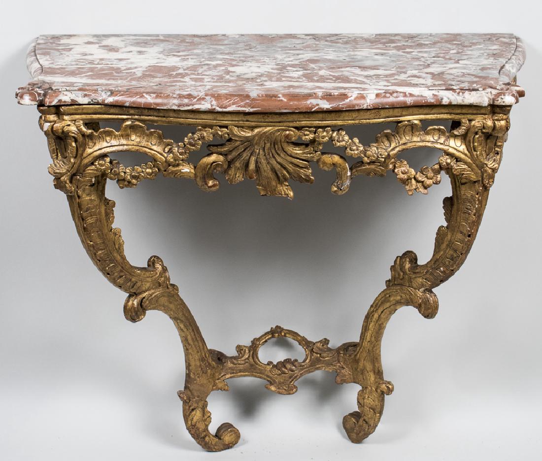 French Marble Top Gilt Console: Rococo style, serpentine front marble top over a carved gilt wood base with scroll, floral swag and shell decoration. Height 32 inches, width 37 inches, depth 20 inches. Notice to bidders: Condition r