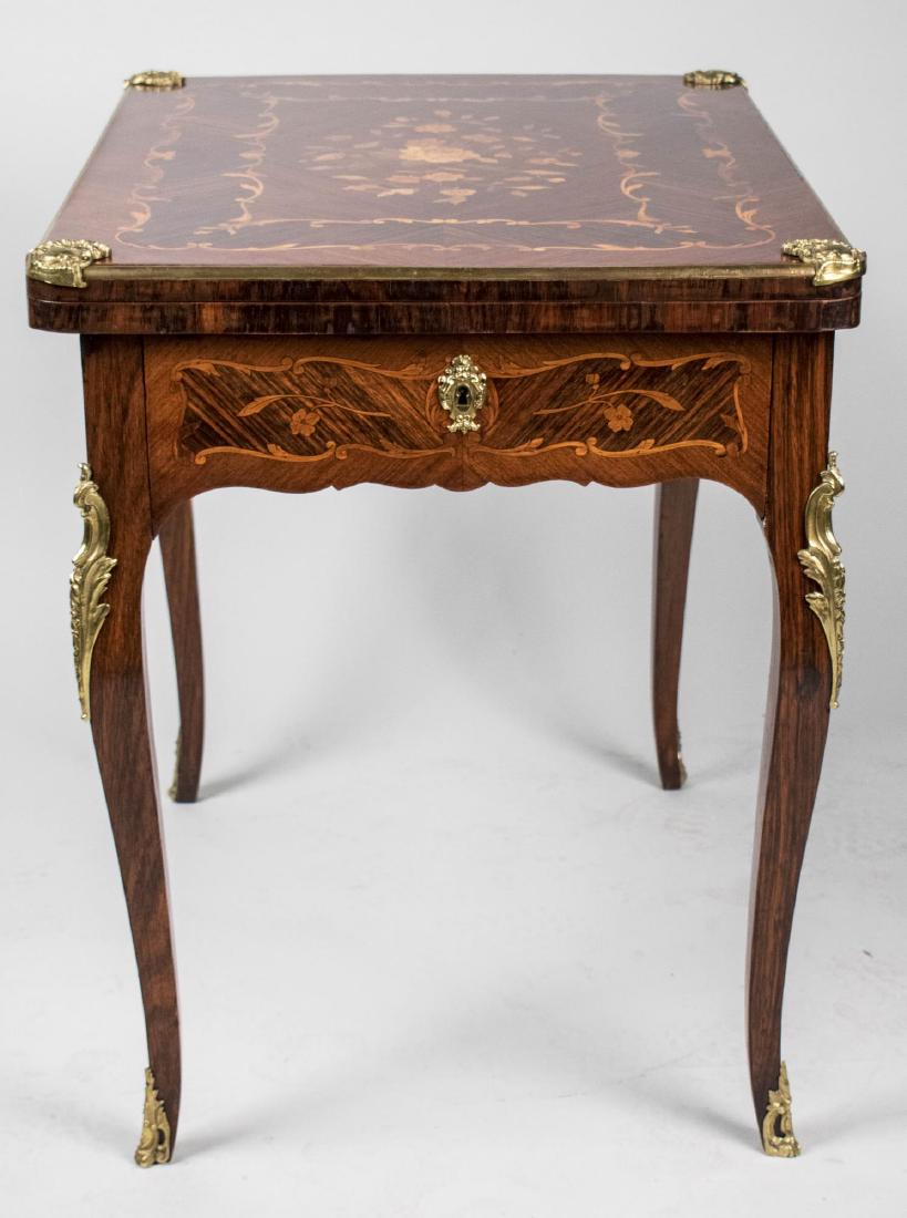 Louis XV Style Marquetry Fold Top Games Table *: Rectangular top inlaid inlaid with floral marquetry, within a crossbanded border and with gilt bronze corners, opening to a baize liner, also a side drawer with game board and storage, gilt bronze mou