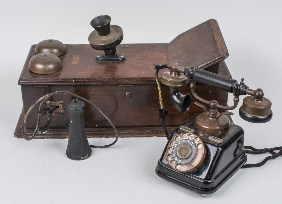 Two Vintage Telephones: One an oak case wall telephone, the other a black rotary dial desk telephone. Wall phone, height 20 1/2 inches. Notice to bidders: Condition reports and additional photographs are provided by request 