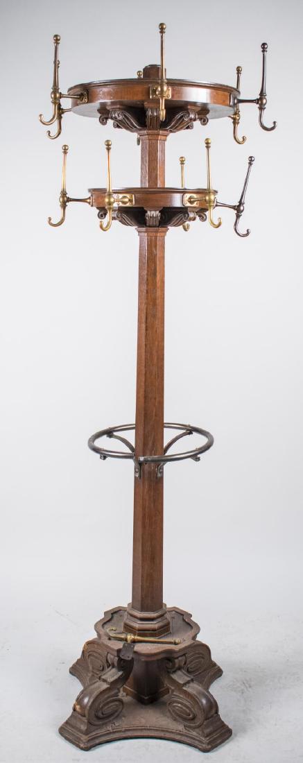 Coat Rack: Twelve hooks on two tiers, on a columnar support with medial umbrella stand, on a quadripartite base with scroll feet. Height 6 feet 6 inches. Notice to bidders: Condition reports and additional photo