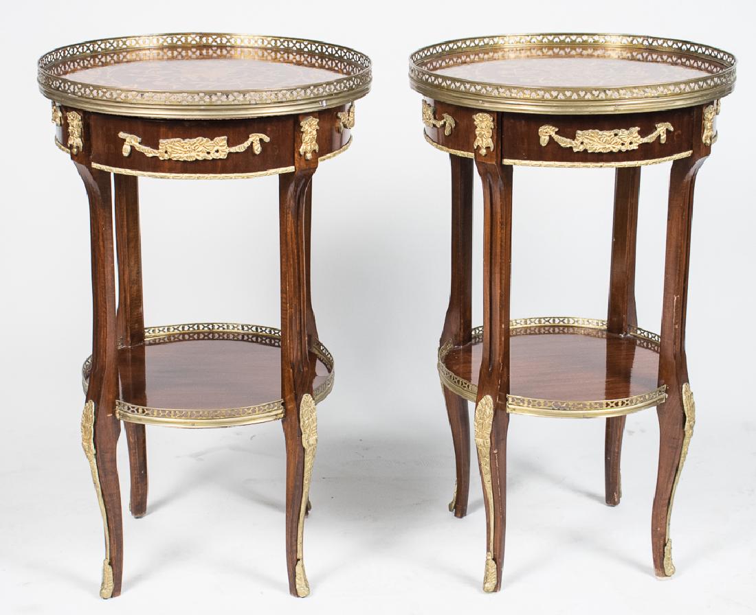 Pair of Continental Marquetry Top Tables *: Each a gilt metal mounted neoclassical style table with floral marquetry inlaid oval top with brass gallery, on fluted supports joined by a conforming lower shelf. Height 30 inches, diameter 19 inches