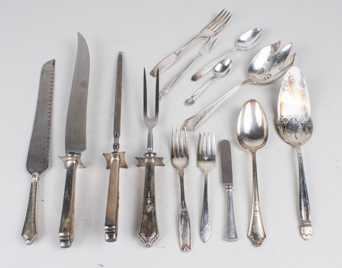 Group of Silver Plated Flatware: Various makers and patterns, including a sterling silver handled three-piece carving set and a sterling handled bread knife. Bread knife, length 13 inches. Notice to bidders: Condition reports and add