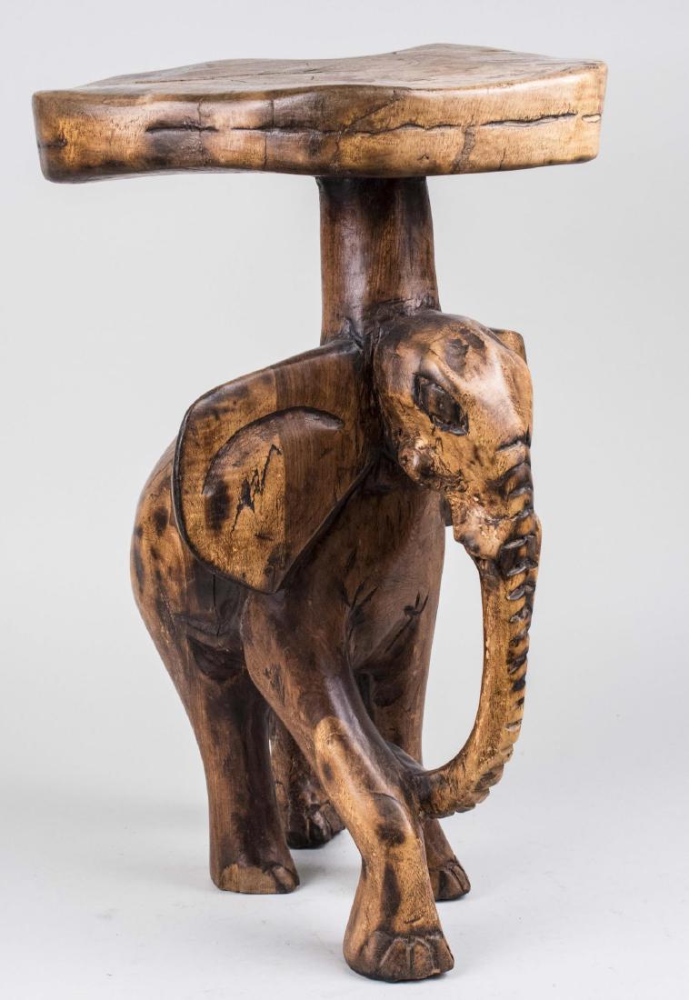 Elephant Table: Circular top on an elephant carved base. Height 22 inches, diameter 13 inches. Notice to bidders: Condition reports and additional photographs are provided by request as a courtesy to our clients, as 