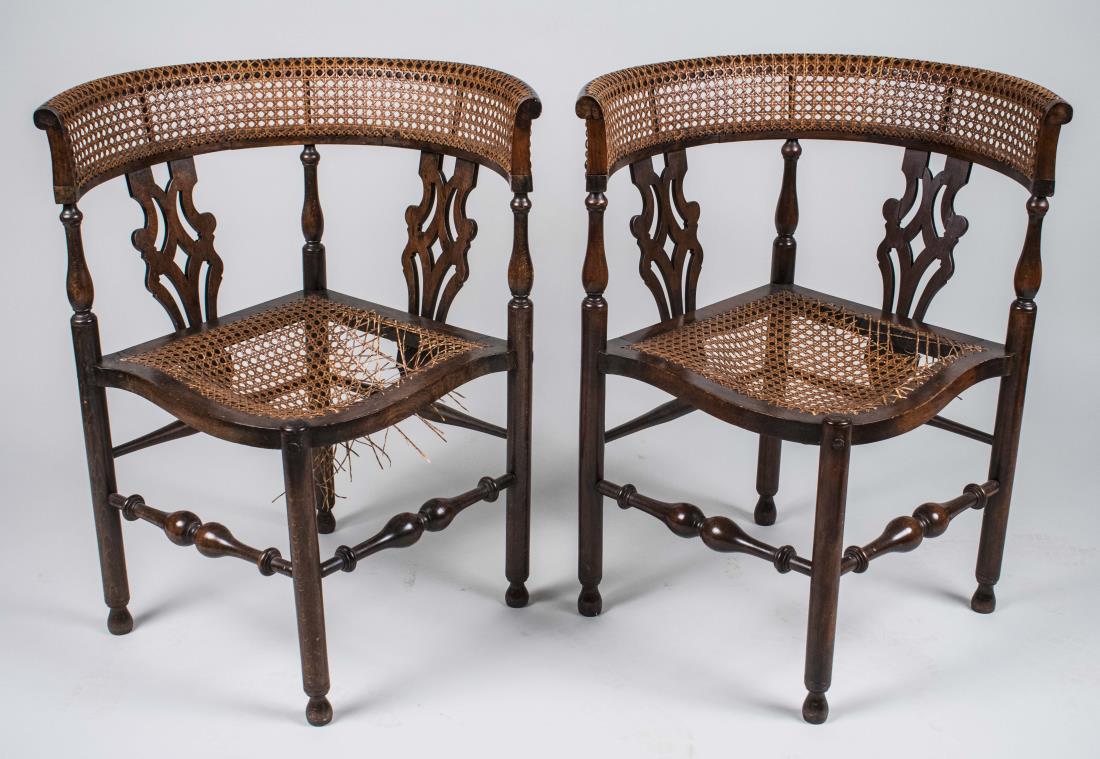 Pair of Caned Corner Chairs: Each with caned crest rail, pierced vertical splats and caned seat, turned legs. Height 30 inches, width 25 inches, depth 25 inches. Notice to bidders: Condition reports and additional photographs are